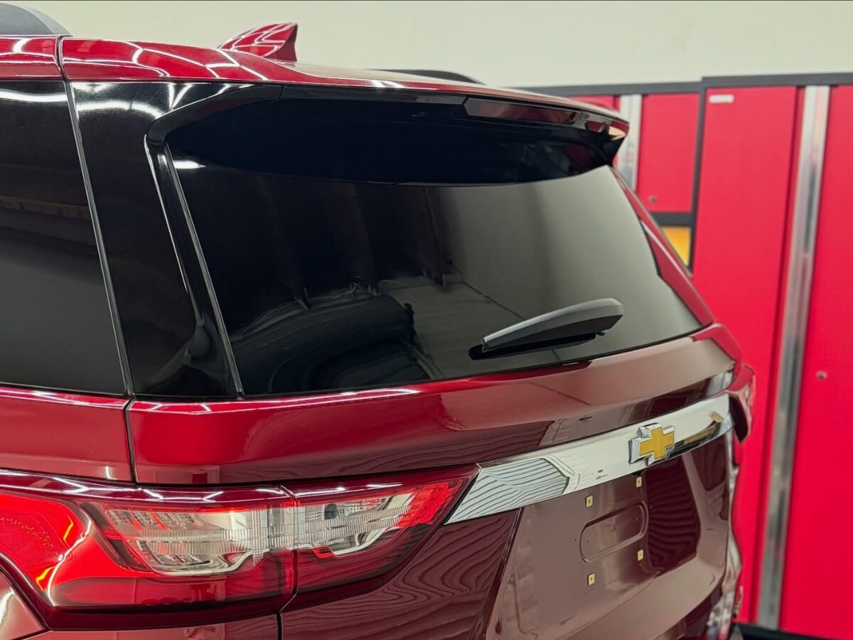 Rear view of red Chevrolet SUV with emblem and tail lights | Icon Auto Lab